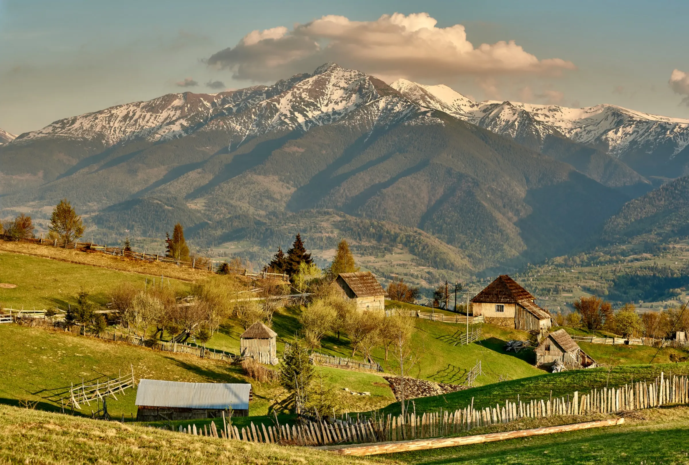Creasta Munților Rodnei cu Vârful Pietrosul, deasupra unui sat din Maramureș